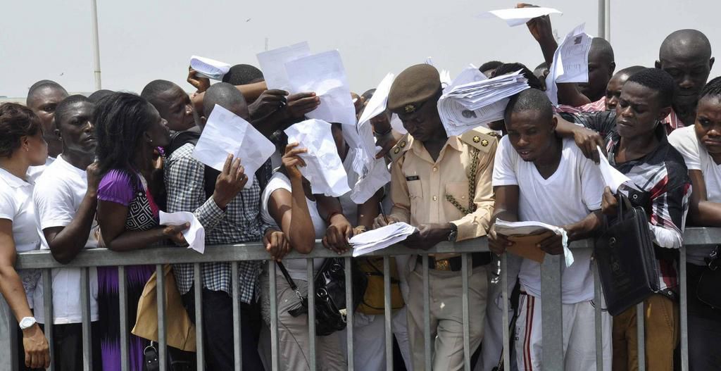 Job-seekers lie on the pitch after a stampede in Abuja National Stadium during the Nigerian immigration recruitment in 2014.