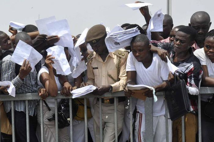 Job-seekers lie on the pitch after a stampede in Abuja National Stadium during the Nigerian immigration recruitment in 2014.
