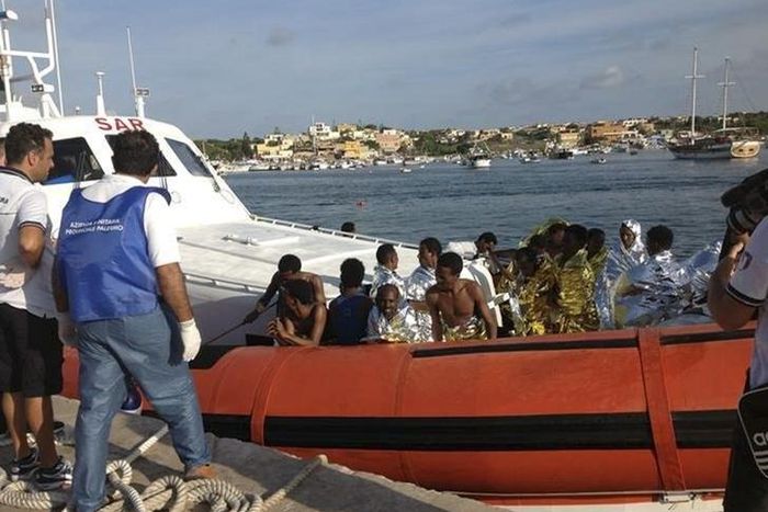 Rescued migrants arrive onboard a coastguard vessel at the harbour of Lampedusa October 3, 2013. REUTERS/Nino Randazzo/ASP press office/Handout via Reuters