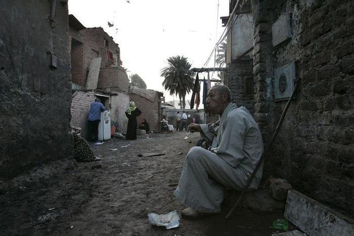 A man eats outside his shanty on World Poverty Day in a Cairo slum, in a file photo. REUTERS/Nasser Nuri