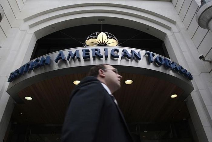 A man walks past the British American Tobacco offices in London, in a file. REUTERS/Luke MacGregor