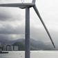 A Chinese aircraft carrier sails past a wind turbine as it sails into Hong Kong on July 7, 2017