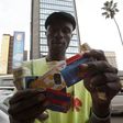 Qualified carpenter Alex Mhazo sells mobile phone cards in central Harare, in this picture taken April 1, 2014. REUTERS/Philimon Bulawayo