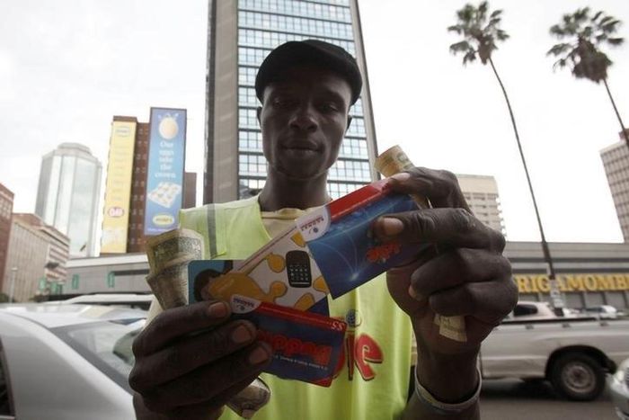 Qualified carpenter Alex Mhazo sells mobile phone cards in central Harare, in this picture taken April 1, 2014. REUTERS/Philimon Bulawayo