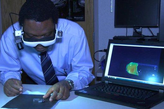 Dr. Samuel Achilefu demonstrating the use of the cancer-seeing glasses he developed