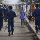 A woman passes by policemen during a protest against Burundi President Pierre Nkurunziza and his bid for a third term in Bujumbura, Burundi, June 2, 2015. REUTERS/Goran Tomasevic