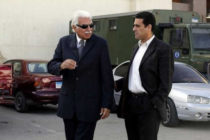 Former Egyptian Prime Minister Ahmed Nazif (L) walks with his son outside of a court after his trial was delayed, in the outskirts of Cairo, December 29, 2014.  REUTERS/Asmaa Waguih
