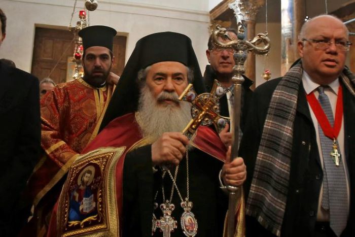 Jerusalem's Greek Orthodox Patriarch Theophilos III (C), arrives at the Church of the Nativity in the occupied West Bank town of Bethlehem, to celebrate the Christmas mass with his community, on January 6, 2019