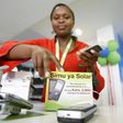 A Safaricom sales representative arranges solar-charged mobile phone handsets for display at a retail centre in Kenya's capital Nairobi, in a file photo. REUTERS/Thomas Mukoya