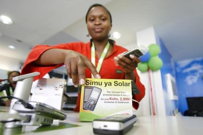 A Safaricom sales representative arranges solar-charged mobile phone handsets for display at a retail centre in Kenya's capital Nairobi, in a file photo. REUTERS/Thomas Mukoya