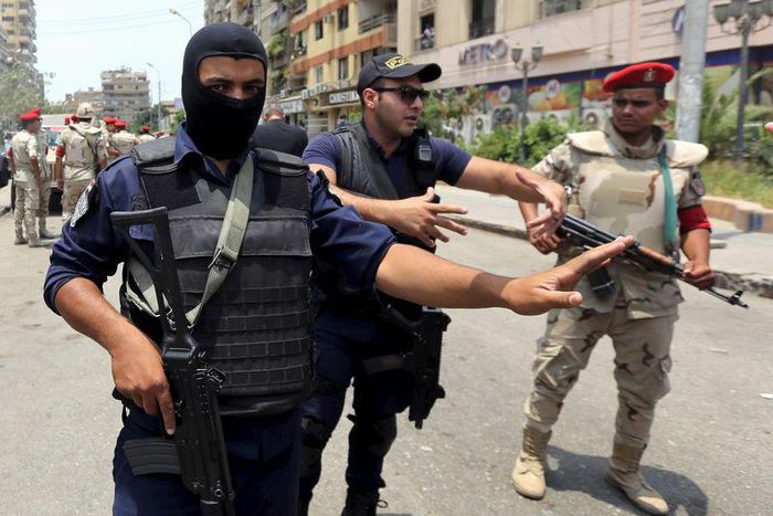 Policemen and army personnel at the site of a car bomb attack on the convoy of Egyptian public prosecutor Hisham Barakat near his house at Heliopolis district in Cairo, Egypt, June 29, 2015. REUTERS/Mohamed Abd El Ghany