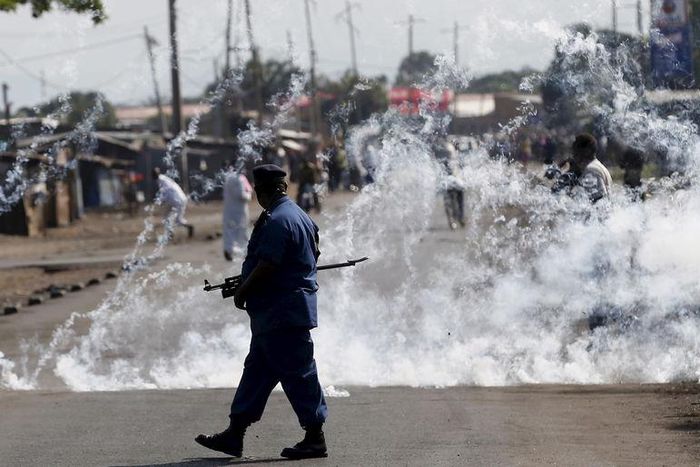 A policeman walks after throwing a teargas canister during a protest against Burundi President Pierre Nkurunziza and his bid for a third term in Bujumbura, Burundi, June 2, 2015. REUTERS/Goran Tomasevic