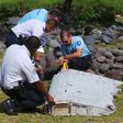 French gendarmes and police inspect a large piece of plane debris which was found on the beach in Saint-Andre, on the French Indian Ocean island of La Reunion, July 29, 2015.