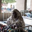 A woman rests with her twin babies in a maternity ward in Maiduguri, Borno State on March 25, 2015