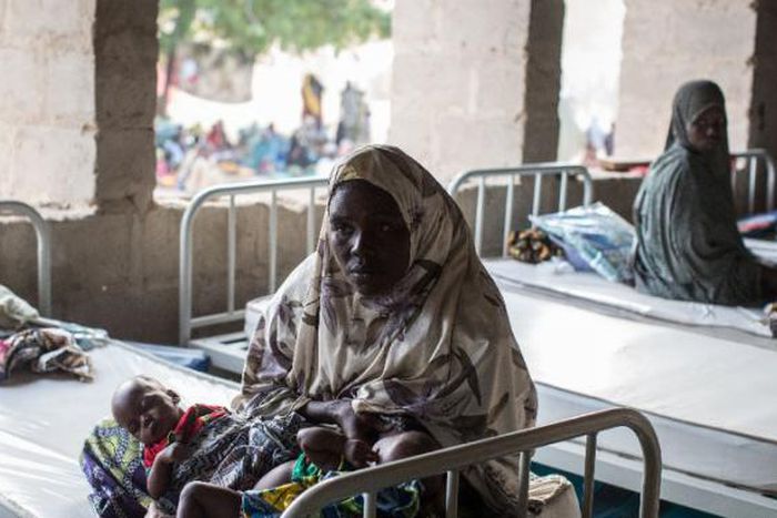 A woman rests with her twin babies in a maternity ward in Maiduguri, Borno State on March 25, 2015