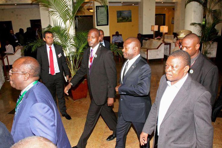 Burundi President Pierre Nkurunziza, (surrounded by security officers), is led by Tanzania Director General of Intelligence and Security Services, (DG-TISS), Rashid Othman (L), on his way to the Julius Nyerere International Airport in Dar es Salaam, Ta...