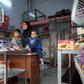 Umm Mustapha, a 27-year-old widow, with her sons in her grocery shop in Iraq's northern city of Mosul on November 28, 2018