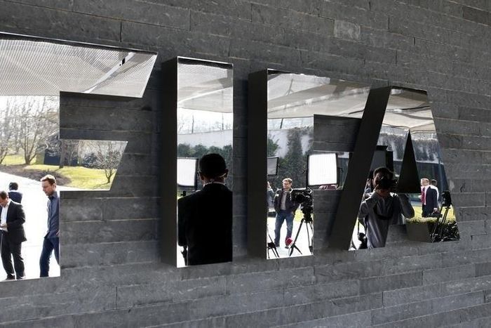Journalists are reflected in the FIFA logo as they wait for a news conference after a meeting of the FIFA executive committee in Zurich March 20, 2015. REUTERS/Arnd Wiegmann