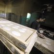 A worker carries trays of bread to be baked in an oven at a bakery in Cairo March 17, 2013. REUTERS/Mohamed Abd El Ghany