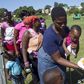 Women with children, who are the first to receive food, stand on a sports field in Chatsworth in the south of Durban April 9, 2015.    REUTERS/Rogan Ward