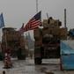 A line of US military vehicles drive through a checkpoint of the Internal Security Forces in Manbij as they head to their base on the outskirts of the northern Syrian city