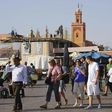 Tourists walk around the Argana restaurant (background) at Marrakesh?s famous Jemma el-Fnaa square, June 22, 2012. REUTERS/Abderrahmane Mokhtari