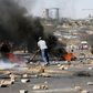A protester sets tyres alight while protesting against what they called the unaffordable electricity prices, in Soweto May 6, 2015. South African police fired rubber bullets on Wednesday to disperse angry demonstrators who set tyres alight while protes...