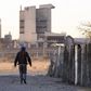 A township resident walks past Lonmin's Marikana platinum mine, in a file photo. REUTERS/Skyler Reid