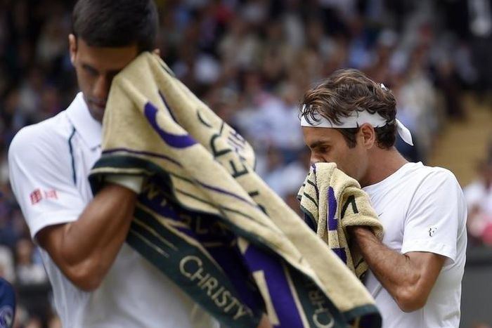 Novak Djokovic of Serbia and Roger Federer of Switzerland wipe their face during their Men's Singles Final match at the Wimbledon Tennis Championships in London, July 12, 2015.                                                     REUTERS/Toby Melville