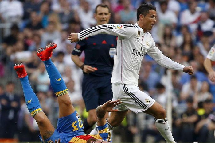 Real Madrid's Cristiano Ronaldo (R) runs past Valencia's Nicolas Otamendi on the ground during their Spanish first division soccer match at Santiago Bernabeu stadium in Madrid, Spain, May 9, 2015.  REUTERS/Paul Hanna      TPX IMAGES OF THE DAY