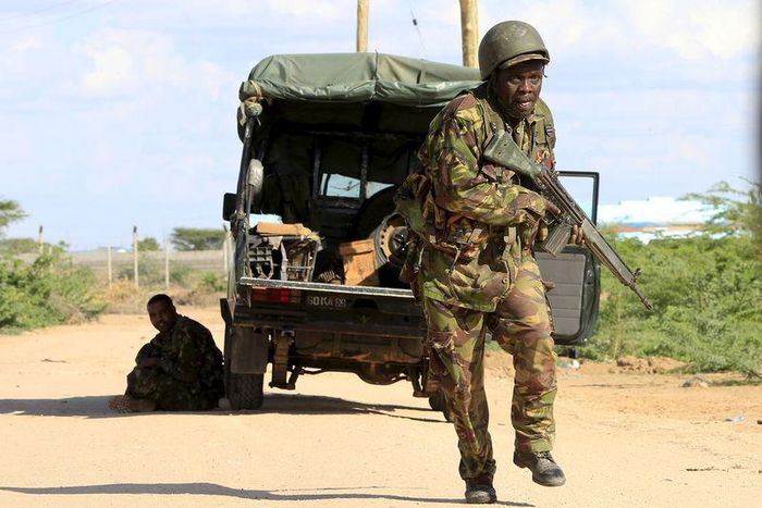 A Kenya Defense Force soldier runs for cover near the perimeter wall where attackers are holding up at a campus in Garissa April 2, 2015. REUTERS/Noor Khamis