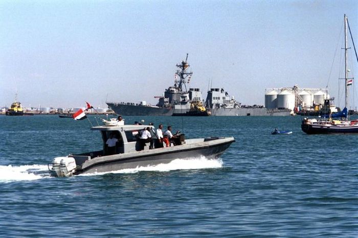 Yemeni marine police patrol around the damaged destroyer USS Cole as it is towed out of Aden harbor on October 29, 2000 -- US President Donald Trump has confirmed that a key plotter of the attack was killed in a US air strike