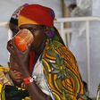 A Burundian refugee woman carries her child as she drinks from a cup at a makeshift clinic at the Lake Tanganyika stadium in Kigoma western Tanzania, May 19, 2015.    REUTERS/Thomas Mukoya