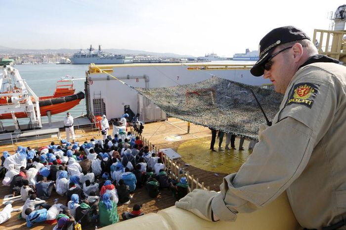 A crew member looks on as migrants wait to disembark from the Norwegian vessel Siem Pilot at Catania's harbour, Italy, June 30, 2015. REUTERS/Antonio Parrinello