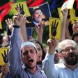 Pro-Islamist demonstrators shout slogans in favour of former Egyptian President Mohamed Mursi and hold signs that show the Rabaa hand gesture, which symbolizes support for the Muslim Brotherhood, during a rally in front of the Haghia Sophia museum at S...