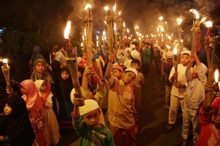 Indonesian Muslim children carry torches  to celebrate the start of Ramadan
