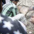 A man is buried up to his neck in rubble as the rescue teams attempt to dig him free from the collapsed building in the capital of Nepal.