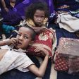 Elah, 7, (L) and Tahye Iselkou, 5, lie next to a box draped with a picture of U.S. President Barack Obama on the floor of their shelter at Mbera refugee camp in southern Mauritania, May 24, 2012. REUTERS/Joe Penney