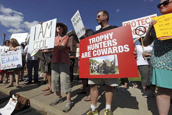 Protesters rally outside the River Bluff Dental clinic against the killing a famous lion in Zimbabwe, in Bloomington, Minnesota July 29, 2015. REUTERS/Eric Miller