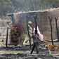 People stand near burnt structures in the aftermath of what Nigerian authorities said was heavy fighting between security forces and Islamist militants in Baga, a fishing town on the shores of Lake Chad, adjacent to the Chadian border, in a file photo....