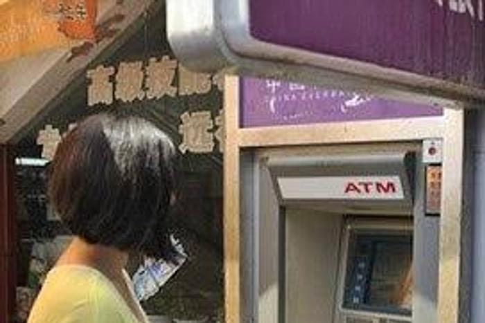 Xiao Liu standing by the ATM that electrocuted her