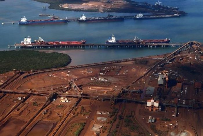 Ships waiting to be loaded are seen near piles of iron ore and bucket-wheel reclaimers at the Fortescue loading dock located at Port Hedland in the Pilbara region of Western Australia, in a file photo. REUTERS/David Gray