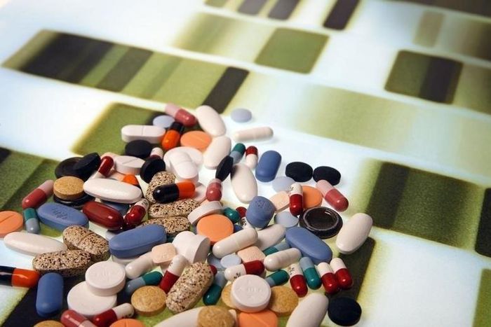 Pharmaceutical tablets and capsules are arranged on a background printed with a DNA pattern in this picture illustration taken in Ljubljana August 20, 2014.    REUTERS/Srdjan Zivulovic