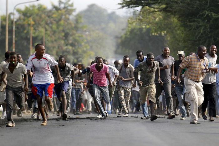 Protesters retreat during clashes with riot police against the decision made by Burundi's ruling National Council for the Defence of Democracy-Forces for the Defence of Democracy (CNDD-FDD) party to allow President Pierre Nkurunziza to run for a third ...
