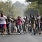 Protesters retreat during clashes with riot police against the decision made by Burundi's ruling National Council for the Defence of Democracy-Forces for the Defence of Democracy (CNDD-FDD) party to allow President Pierre Nkurunziza to run for a third ...