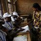 A woman receives ballot papers from election officials at a voting station in Burundi's capital Bujumbura during the country's presidential elections, July 21, 2015. REUTERS/Mike Hutchings