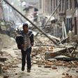 A man runs through ruins as aftershocks hit Kathmandu.
