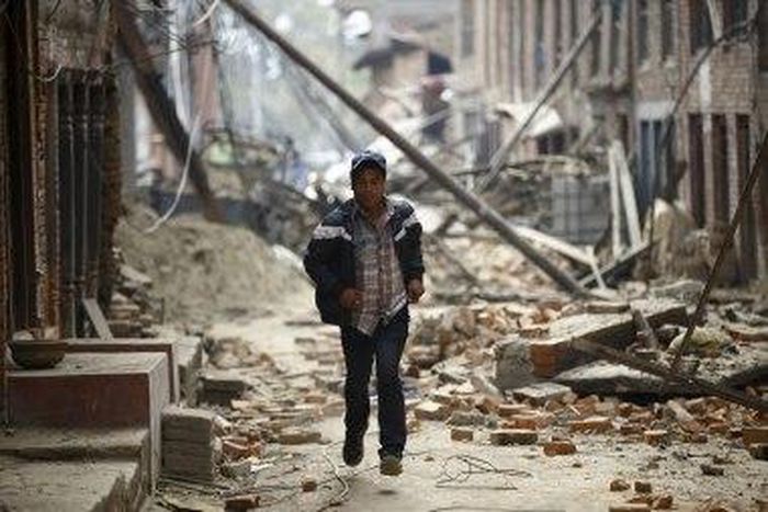 A man runs through ruins as aftershocks hit Kathmandu.