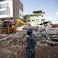 An armed police personnel looking for survivors stands in front of a collapsed house after the earthquake in Kathmandu May 12, 2015.  REUTERS/Navesh Chitrakar