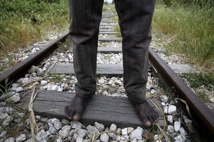 26-year-old Azam from South Sudan stands on rail tracks after failing to flee to Italy in the western Greek town of Patras April 28, 2015.   REUTERS/Yannis Behrakis